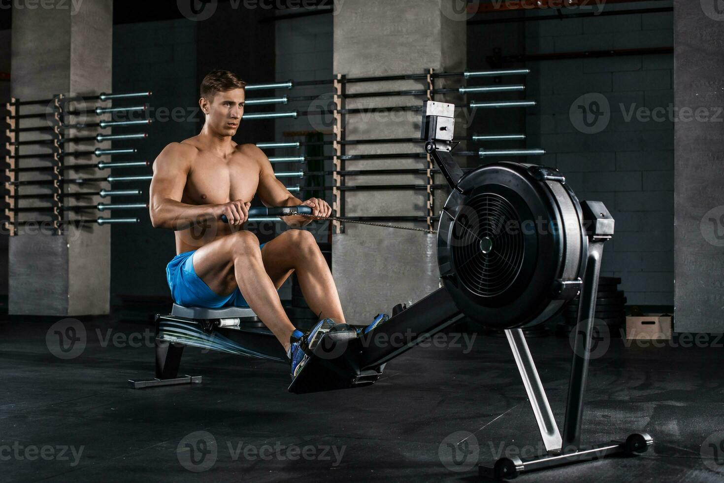 Bodybuilder working on his legs with weight machine at the gym photo