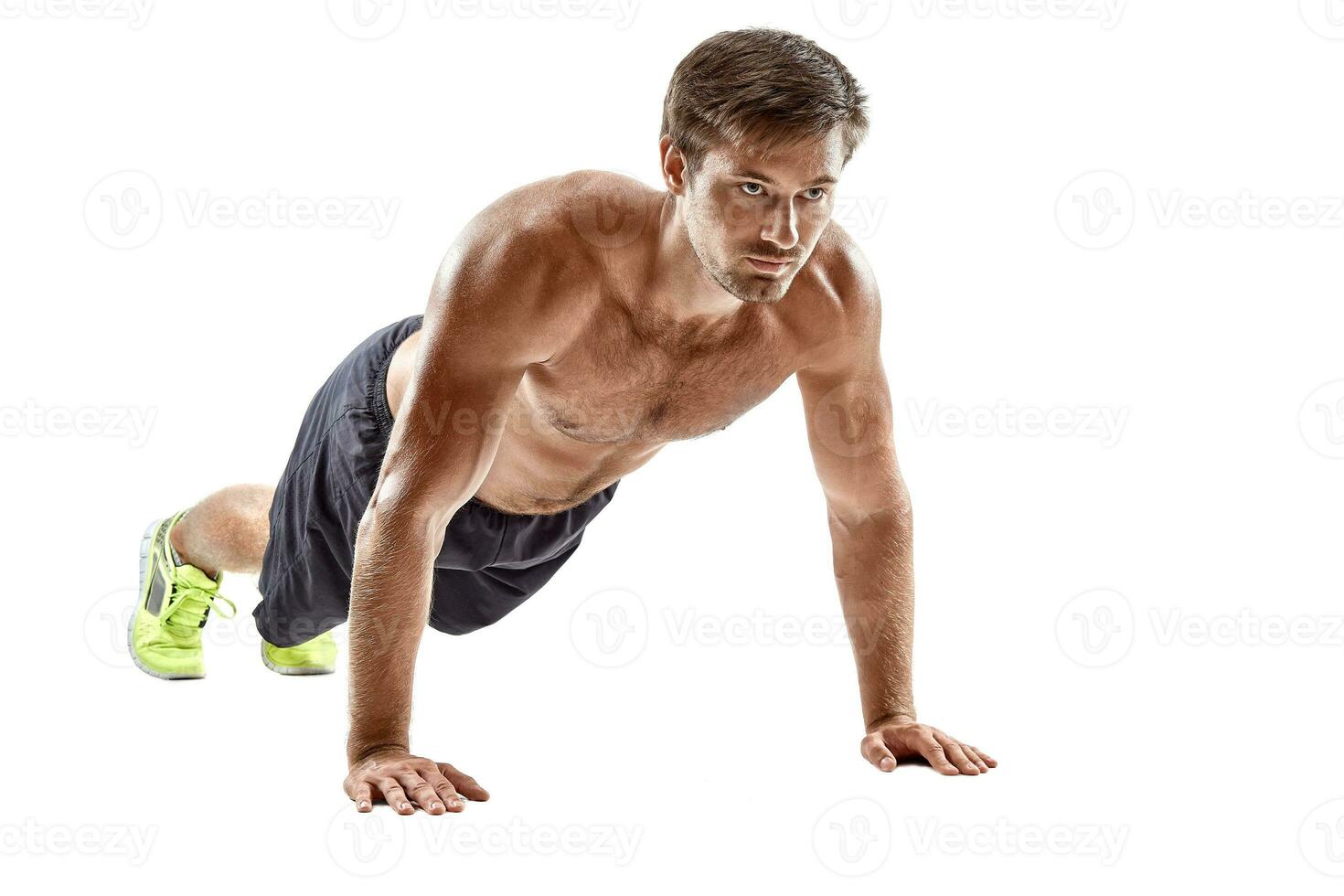 Push up fitness man doing push-up bodyweight exercise on gym floor. Athlete working out chest muscles strength training indoors photo