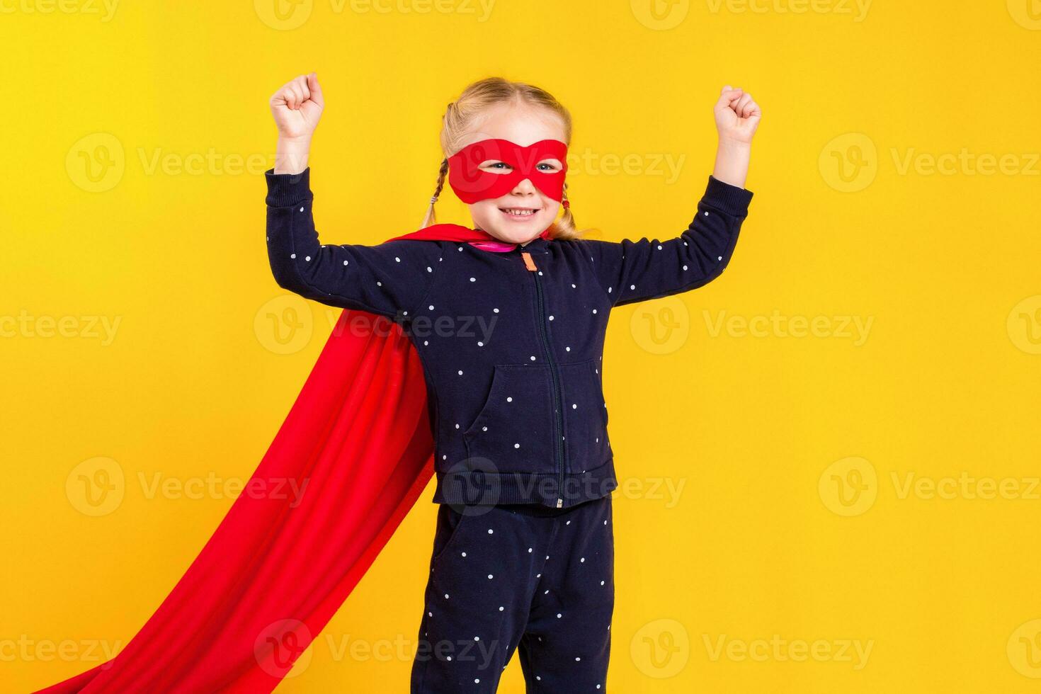 Superhero little girl in a red raincoat and a mask photo