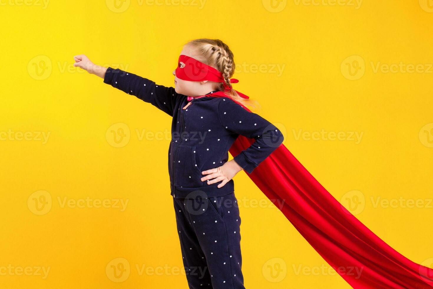 Superhero little girl in a red raincoat and a mask photo