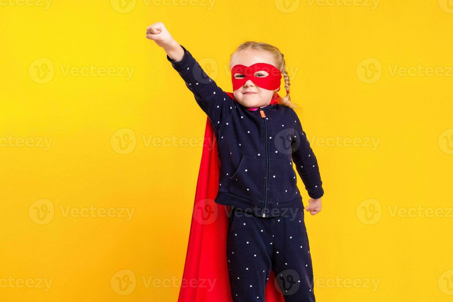 Superhero little girl in a red raincoat and a mask photo