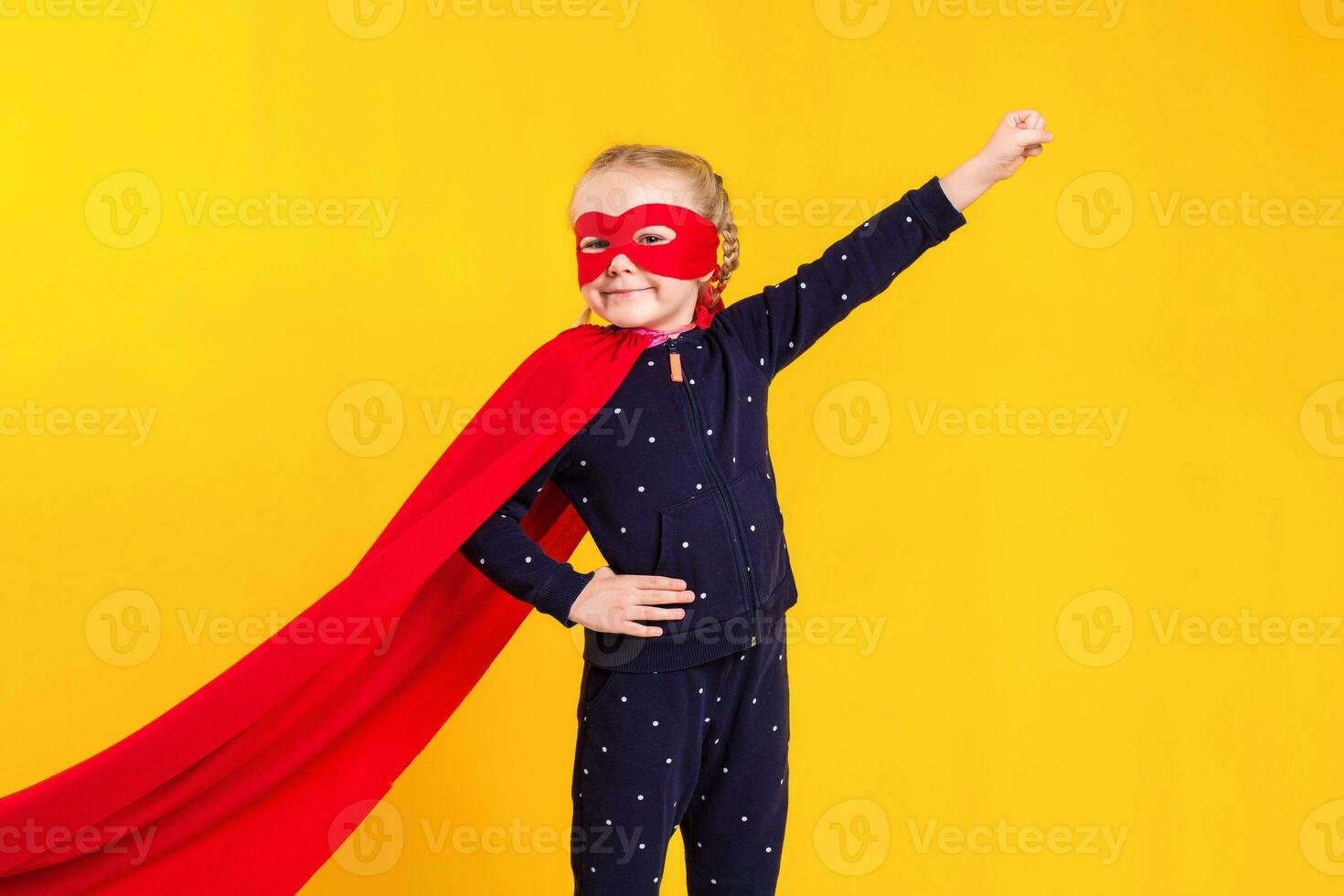 Superhero little girl in a red raincoat and a mask photo