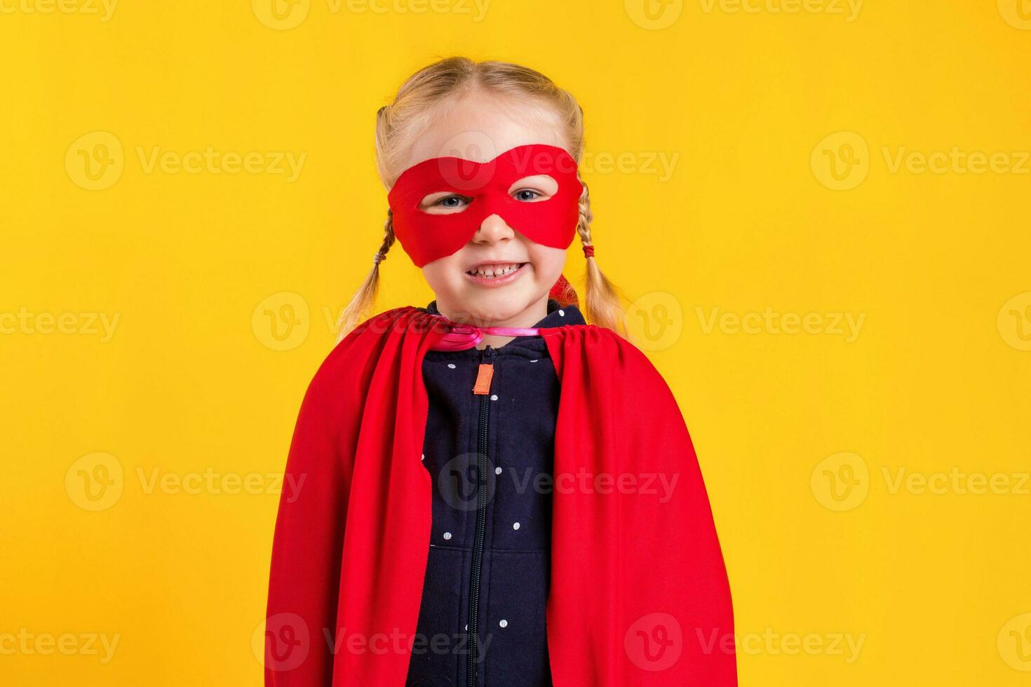 Funny little power superhero child girl in a red raincoat and a mask. Superhero concept. photo