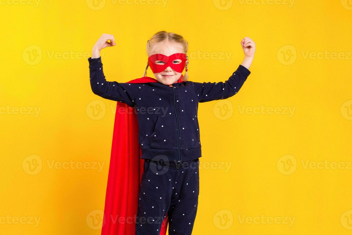 Superhero little girl in a red raincoat and a mask photo