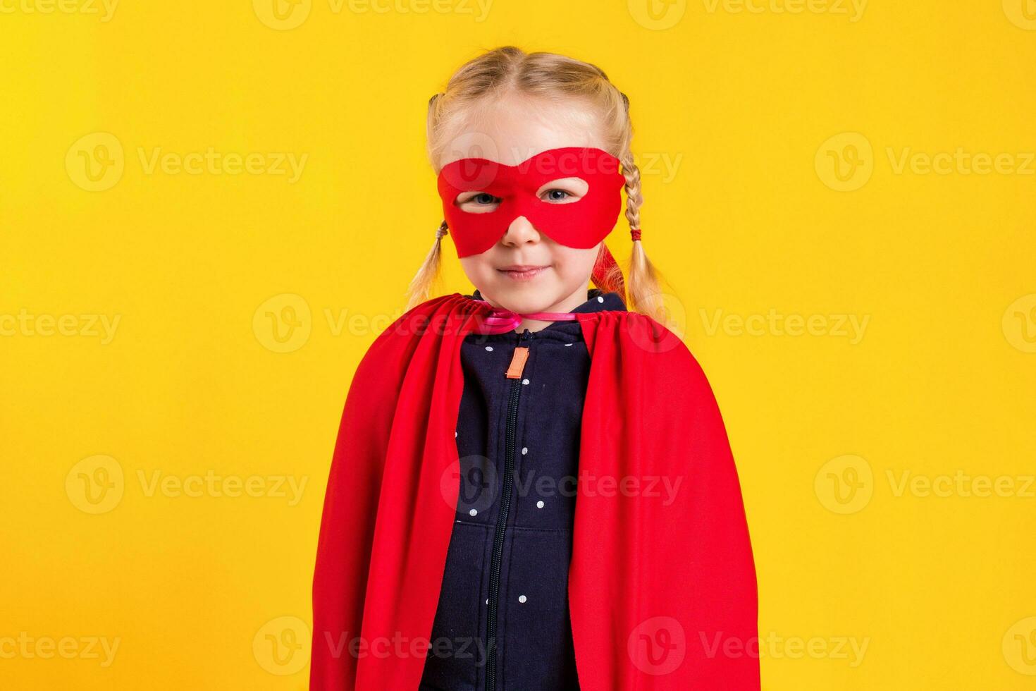 Funny little power superhero child girl in a red raincoat and a mask. Superhero concept. photo