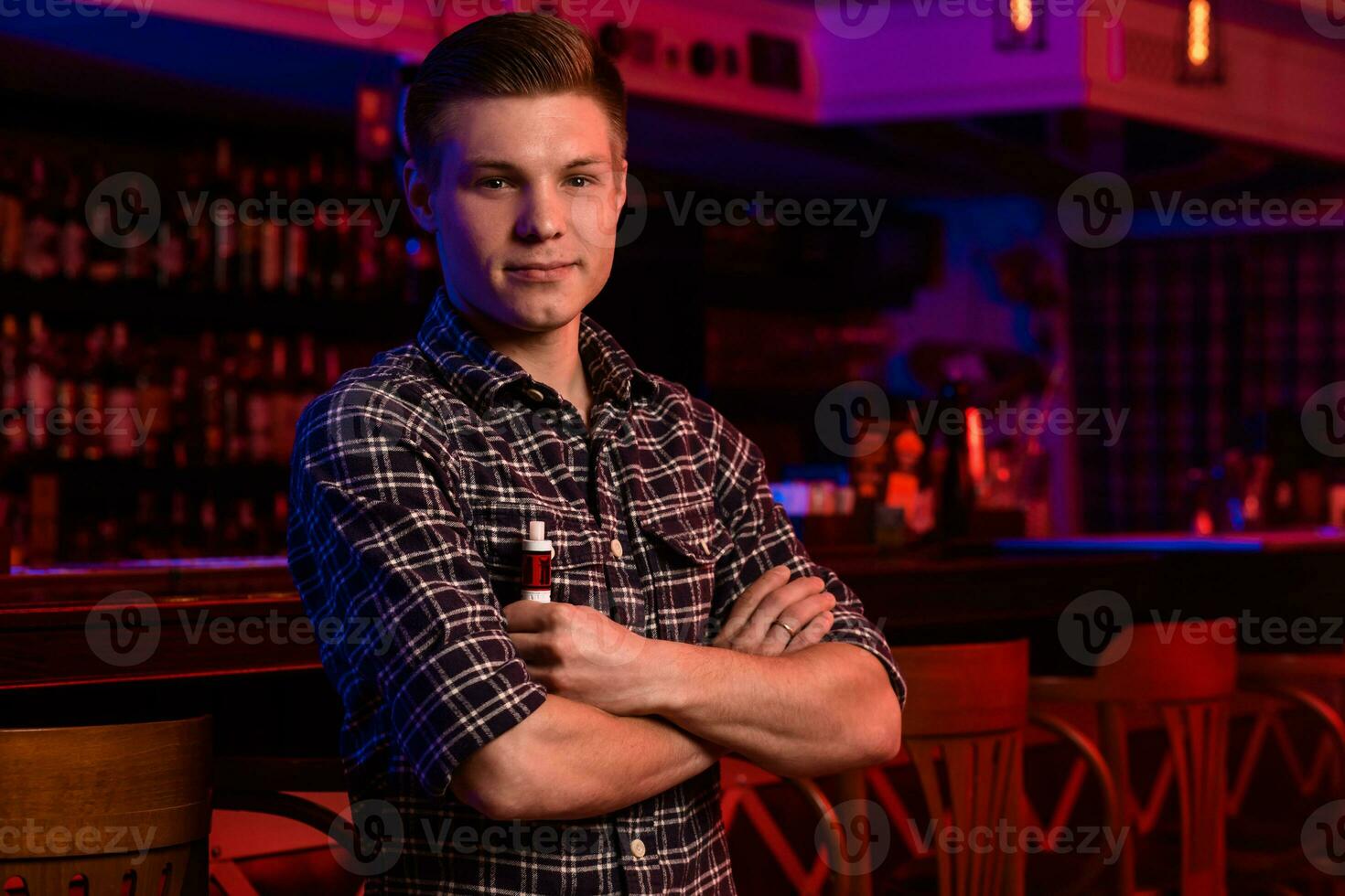 The man smoke an electronic cigarette at the vape shop. photo