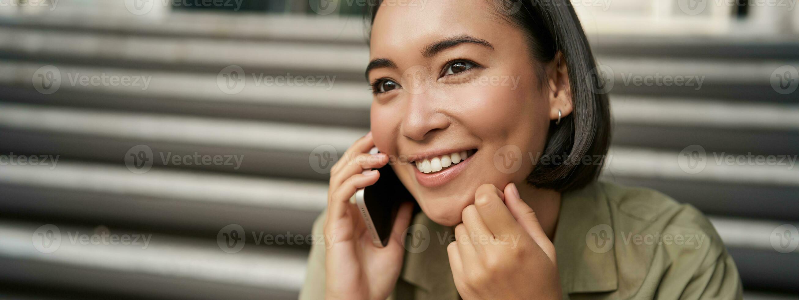 cerca arriba retrato de asiático niña negociaciones en móvil teléfono. joven mujer teniendo un teléfono llamar, utilizando su teléfono foto