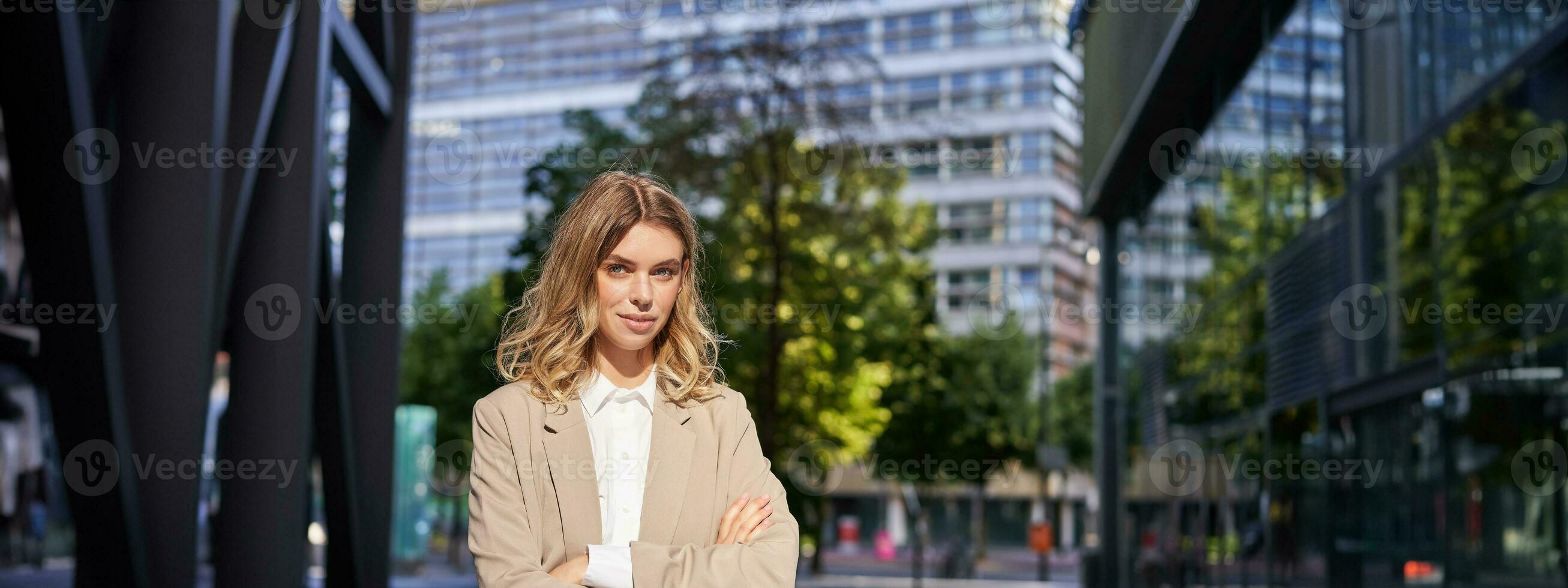 Successful working woman, office manager in suit, cross arms on chest, looking with confidence photo