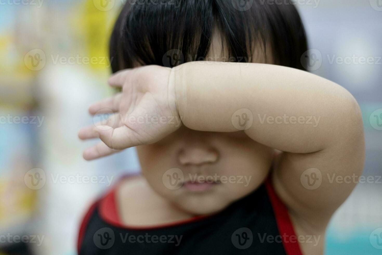 chico participación su brazo en frente de su cara foto