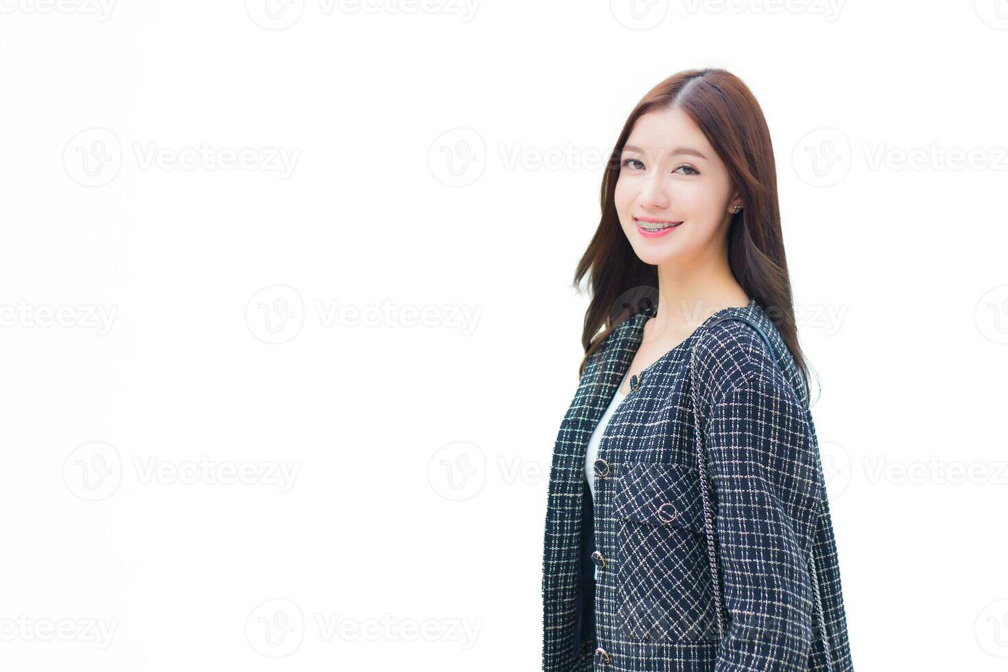 Young professional office Asian woman side face in a black pattern coat with braces on teeth standing and smiling while isolated on white background. photo