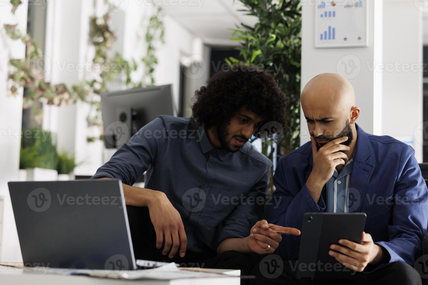 Arab focused employees discussing start up project and analyzing financial data together in business office. Coworkers brainstorming and thinking about marketing campaign in coworking space photo