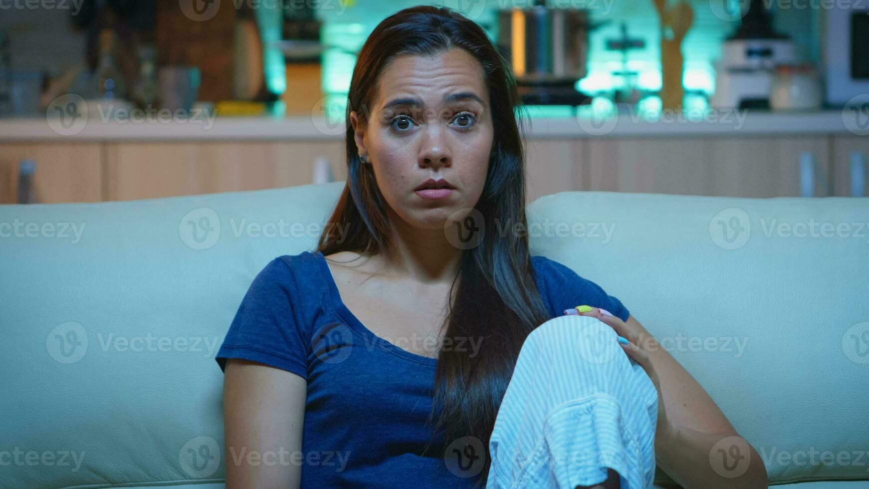 emocionalmente atemorizado y con los ojos muy abiertos mujer reaccionando a un impresionante y asombroso momento en televisor. conmocionado concentrado dama comiendo palomitas de maiz y acecho un interesante de serie hogar solo tarde a noche. foto