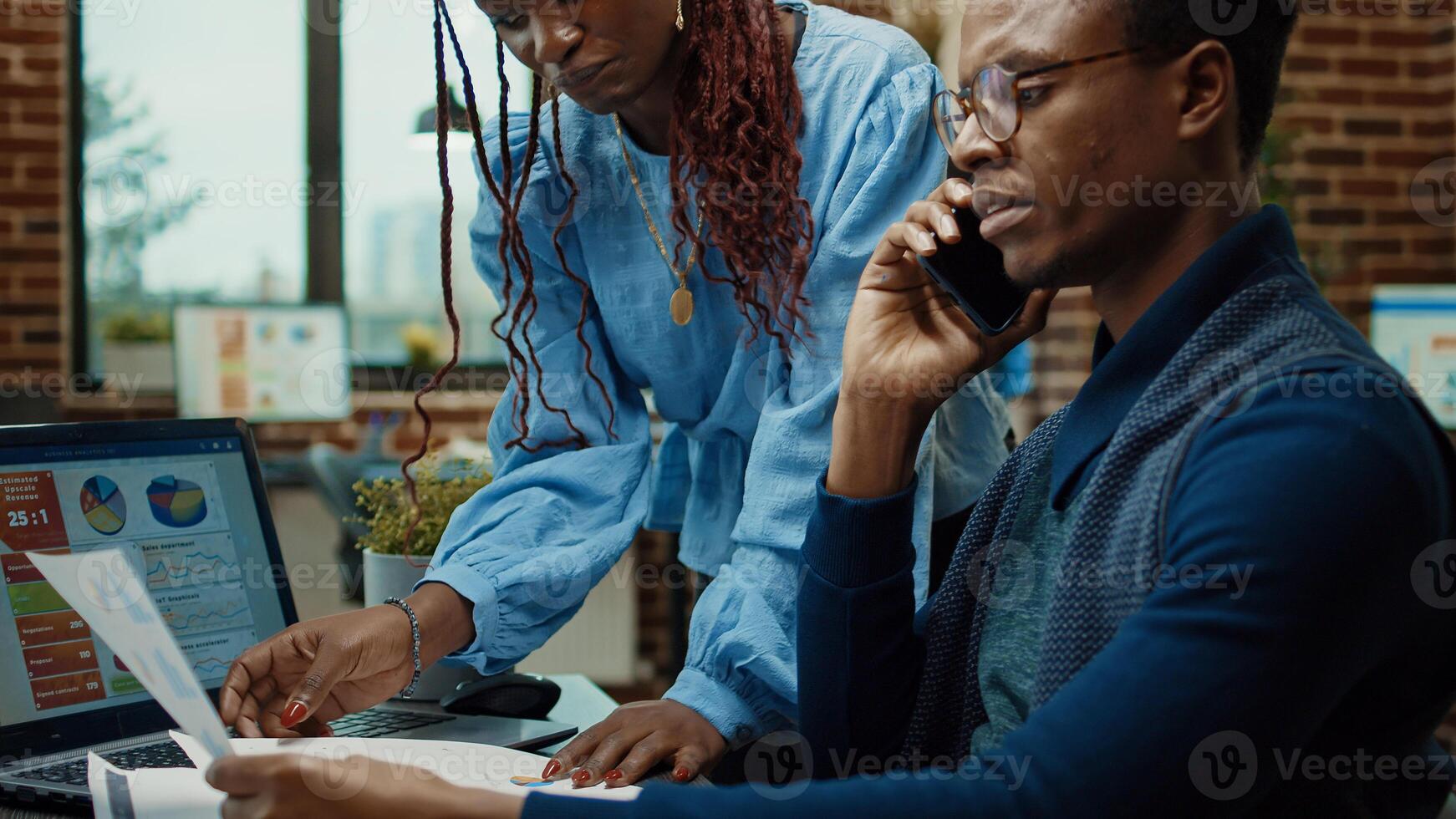 Business partners reviewing data reports, employee talking on phone call to explain new development vision. Male worker using mobile phone line to chat with manager in boardroom office. photo
