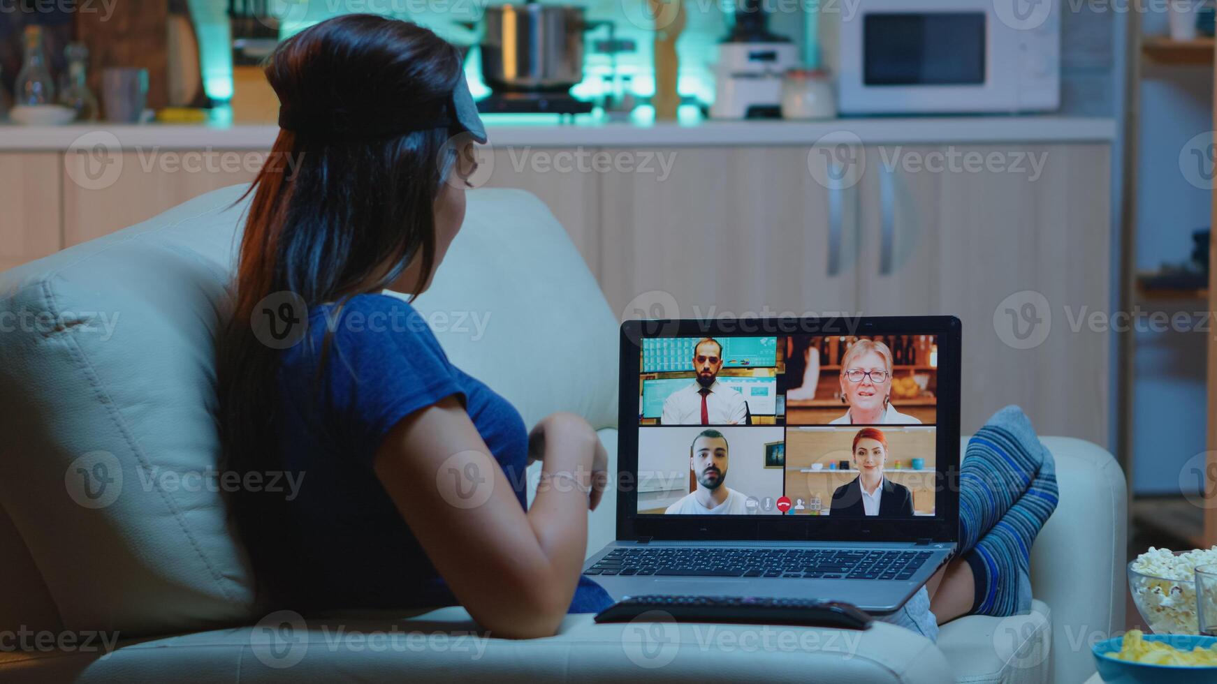 Woman streaming online webinar training at night from home. Remote worker having online meeting, video conference consulting with colleagues using videocall and webcam chat working in front of laptop. photo