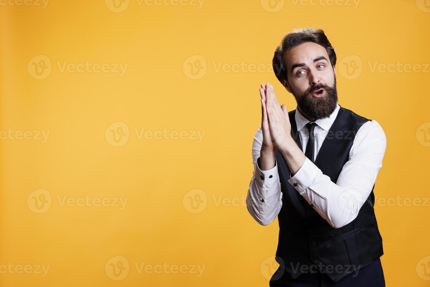 Young adult butler applauding on camera, doing standing ovation gesture and congratulating person on achievement. Male experienced waiter clapping hands and cheering for someone. photo