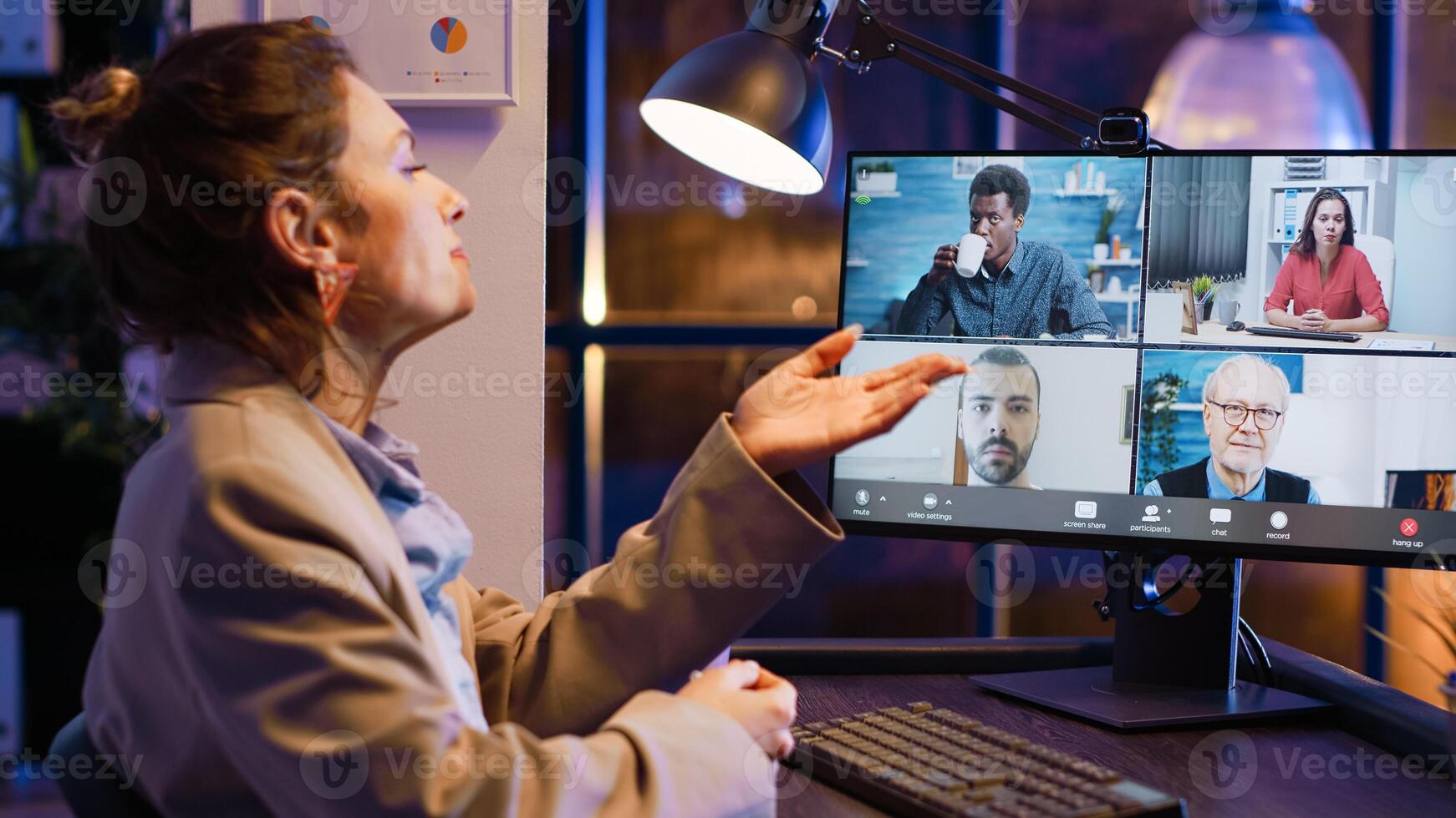 Entrepreneur attending business meeting on video call talking to colleagues about startup investment. Employee using online conference chat late at night, chatting on videoconference. photo