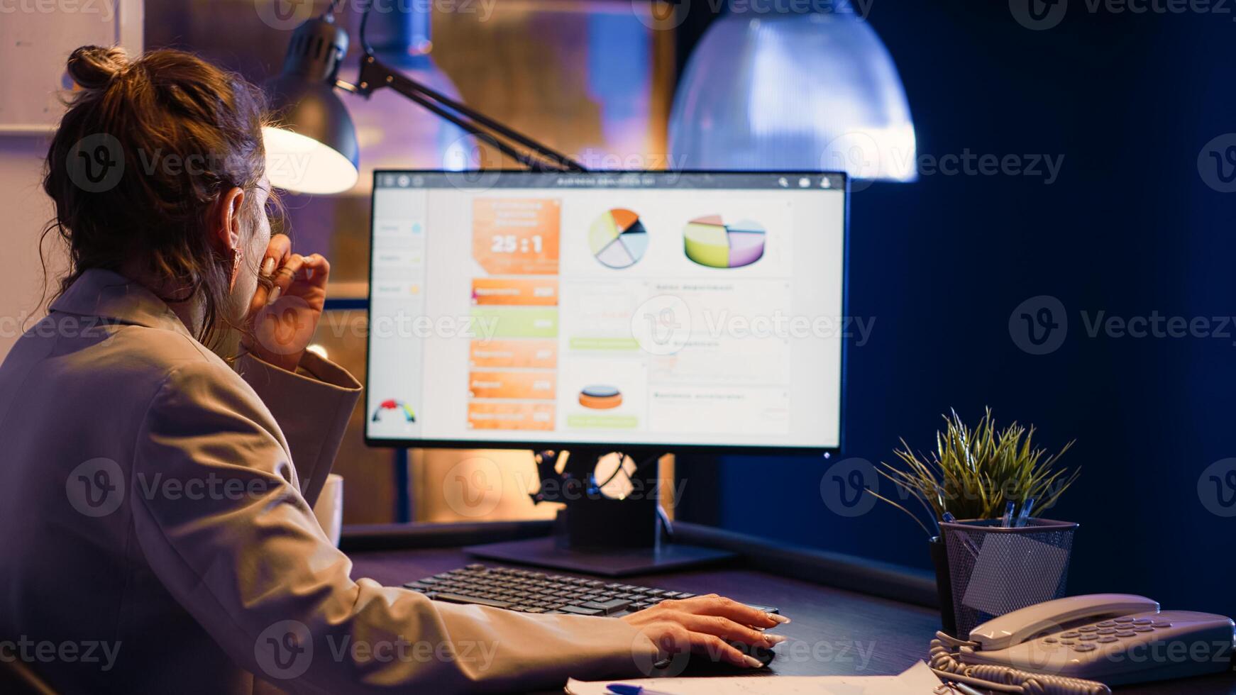 Office worker looking at computer running diagrams on screen, planning economy graphs late at night. Female entrepreneur typing data to create business report, analyzing investment at desk. photo