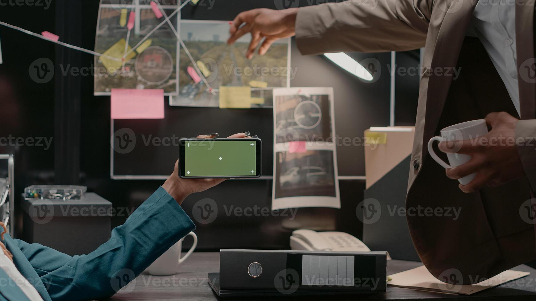 Team of law inspectors analyzing greenscreen display in private investigation archive room, working with copyspace and mockup template. Two detectives looking at chroma key screen. photo