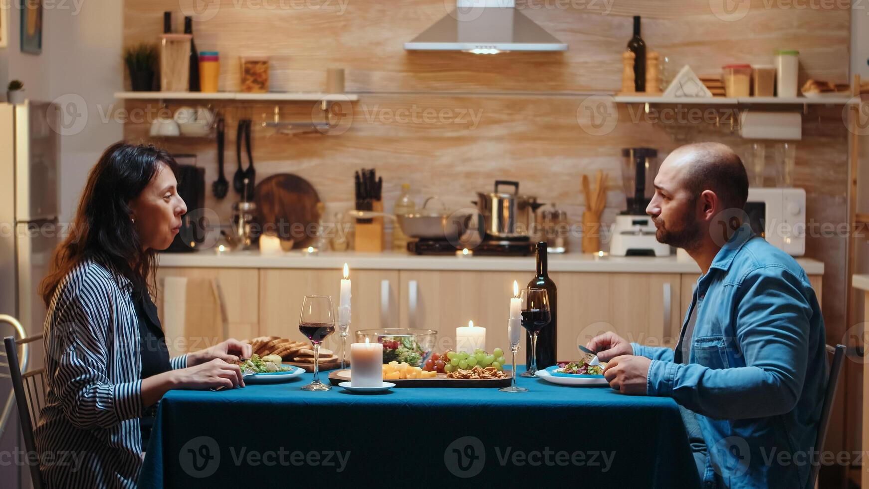 Young happy married couple having video call in kitchen during romantic dinner, eating festive meal. Pov online internet modern conference, chatting, communication, chat conversation call via webcam photo