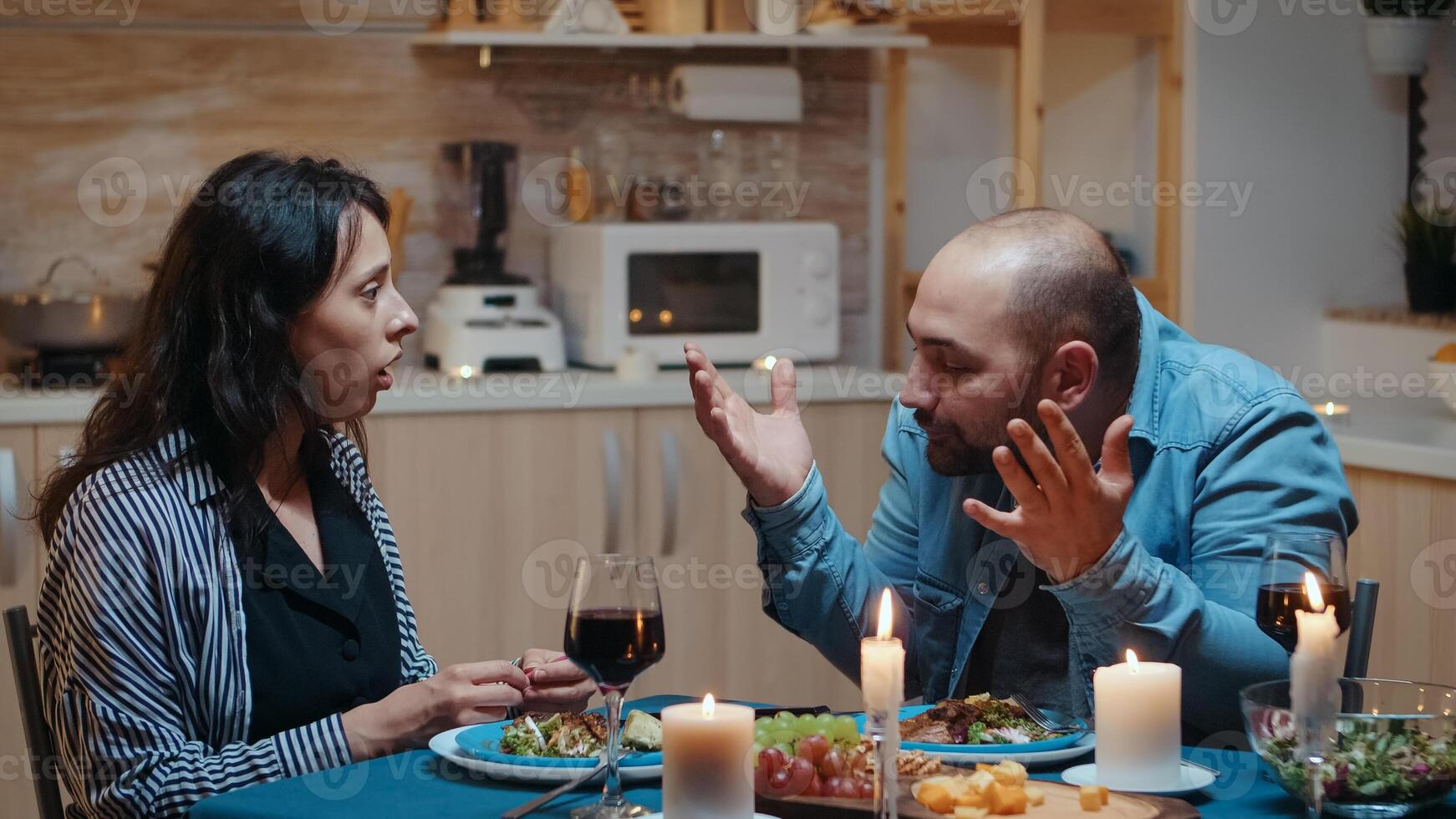 Angry man for positive pragnancy test during romantic dinner. Woman surprising her husband being pregnant, unhappy, nervous, partner, unwanted baby, frustrated for results. photo