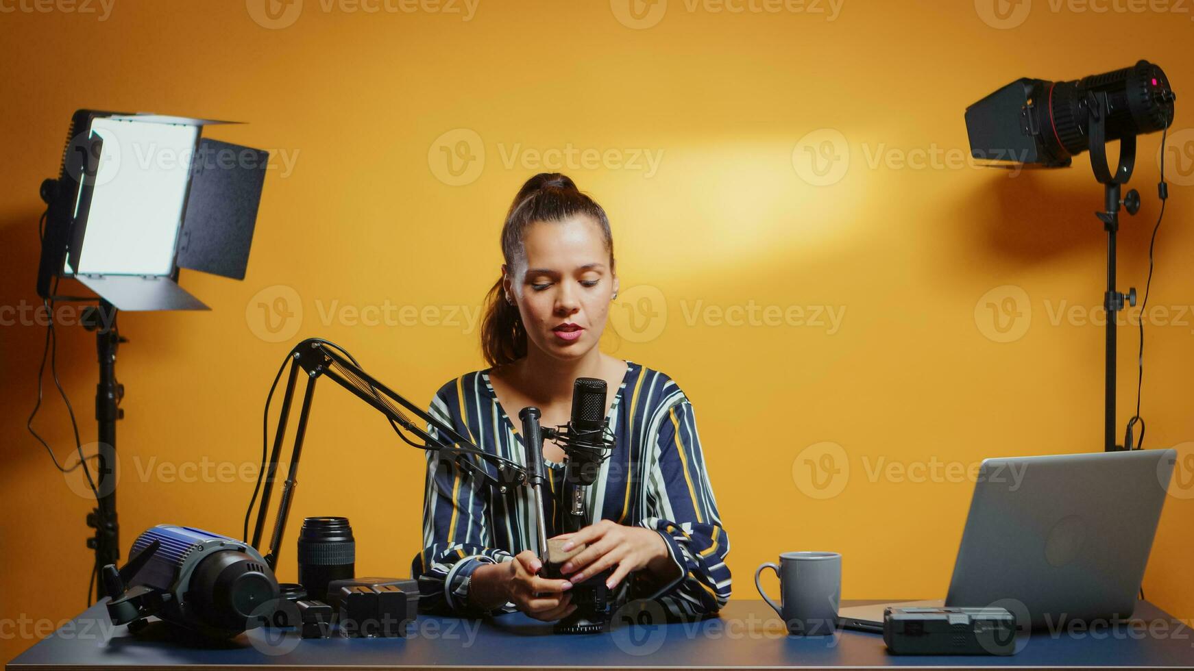 Social media star presenting a fluid tripod head in her professional studio. Influencer making online internet content about video equipment for web subscribers and distribution, digital vlog photo