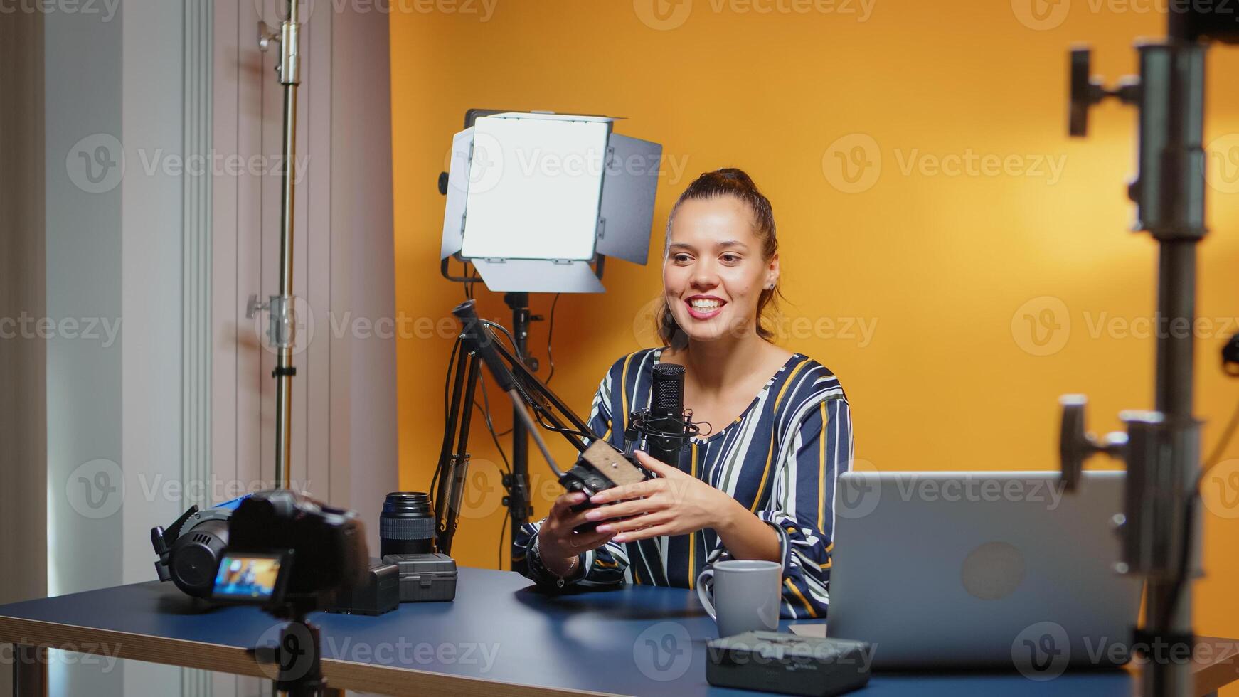 Backstage of vlogger recording to the camera tutorial about fluid heads in professional studio. Influencer making online internet content about video equipment for web subscribers and distribution, digital vlog talking film photo