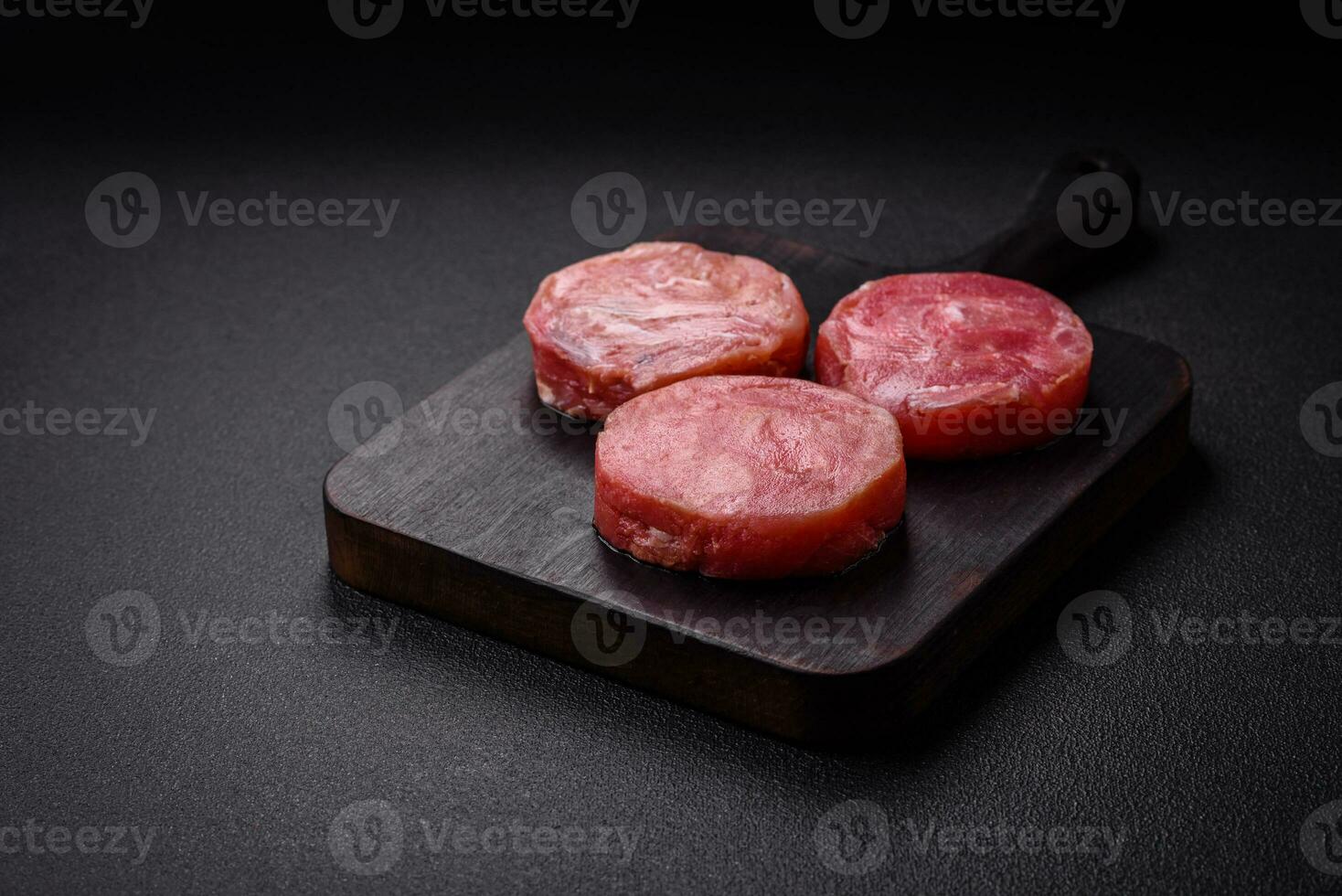 Round shape steaks of raw juicy tuna with salt and spices photo