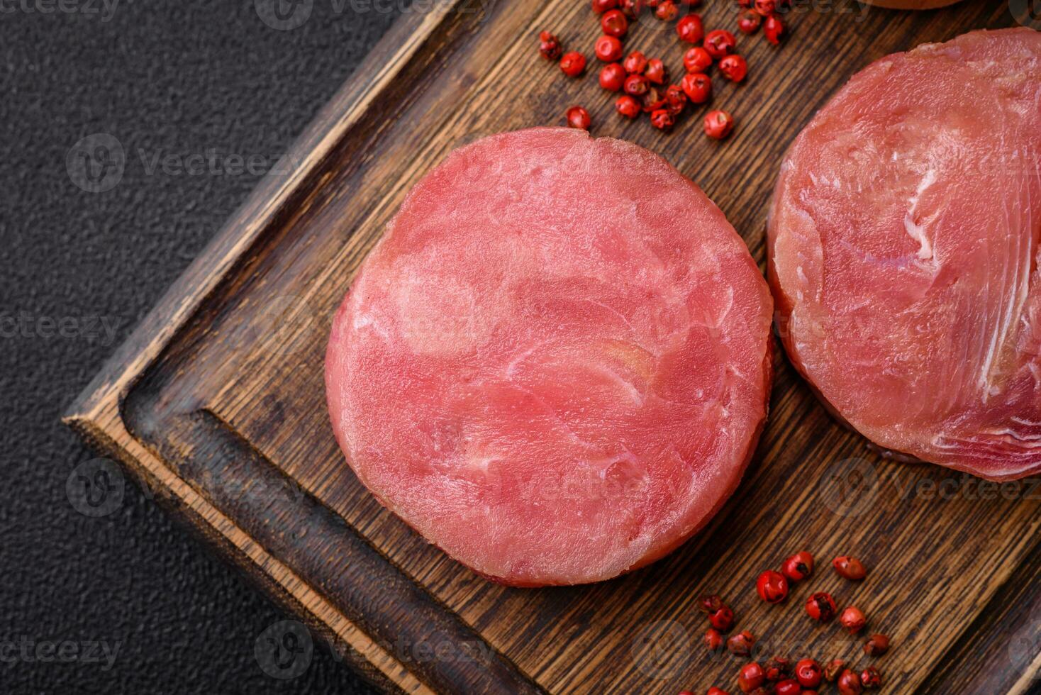 Round shape steaks of raw juicy tuna with salt and spices photo