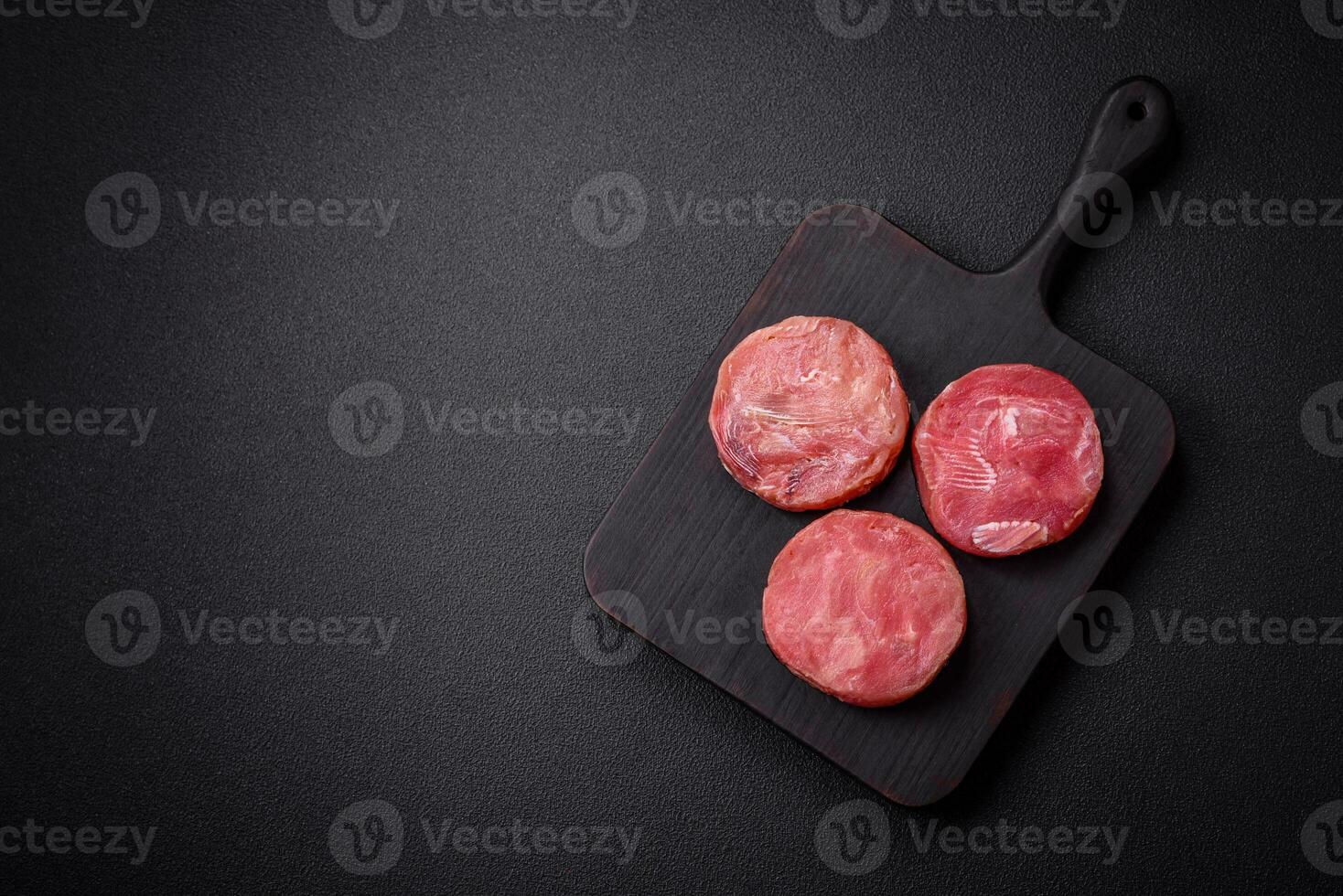 Round shape steaks of raw juicy tuna with salt and spices photo