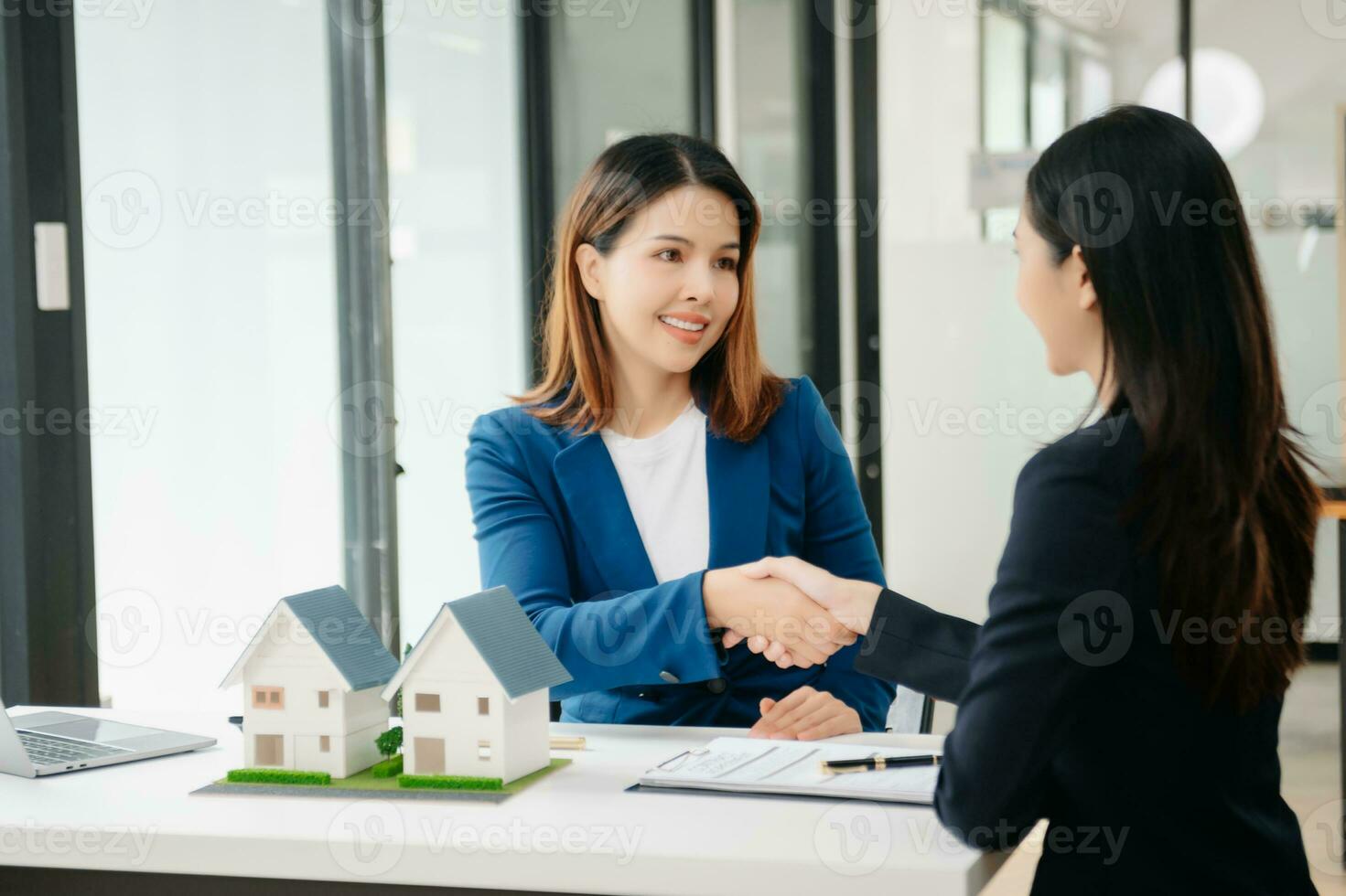 Real estate broker agent presenting and consult to customer to decision making sign insurance form agreement, home model, concerning mortgage loan offer photo