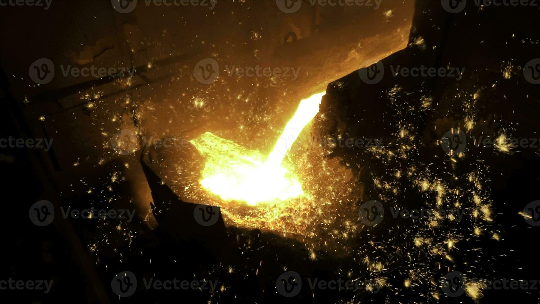 Pouring of liquid metal in open hearth workshop of the metallurgical plant. Stock footage. Smelting of the metal in the foundry at steel mill. photo