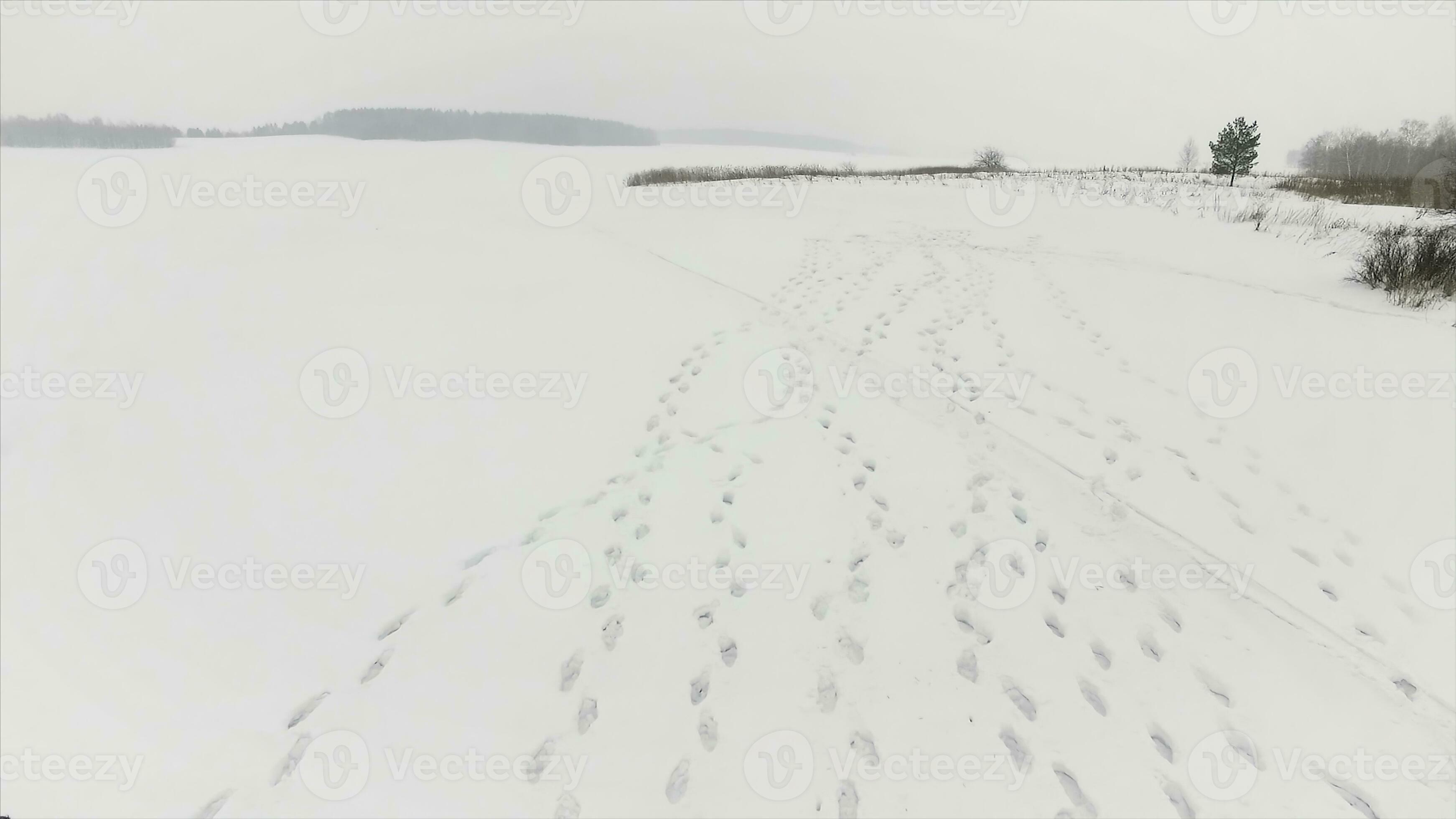Footprints in the snow. Footage. Top view on three footprints in the