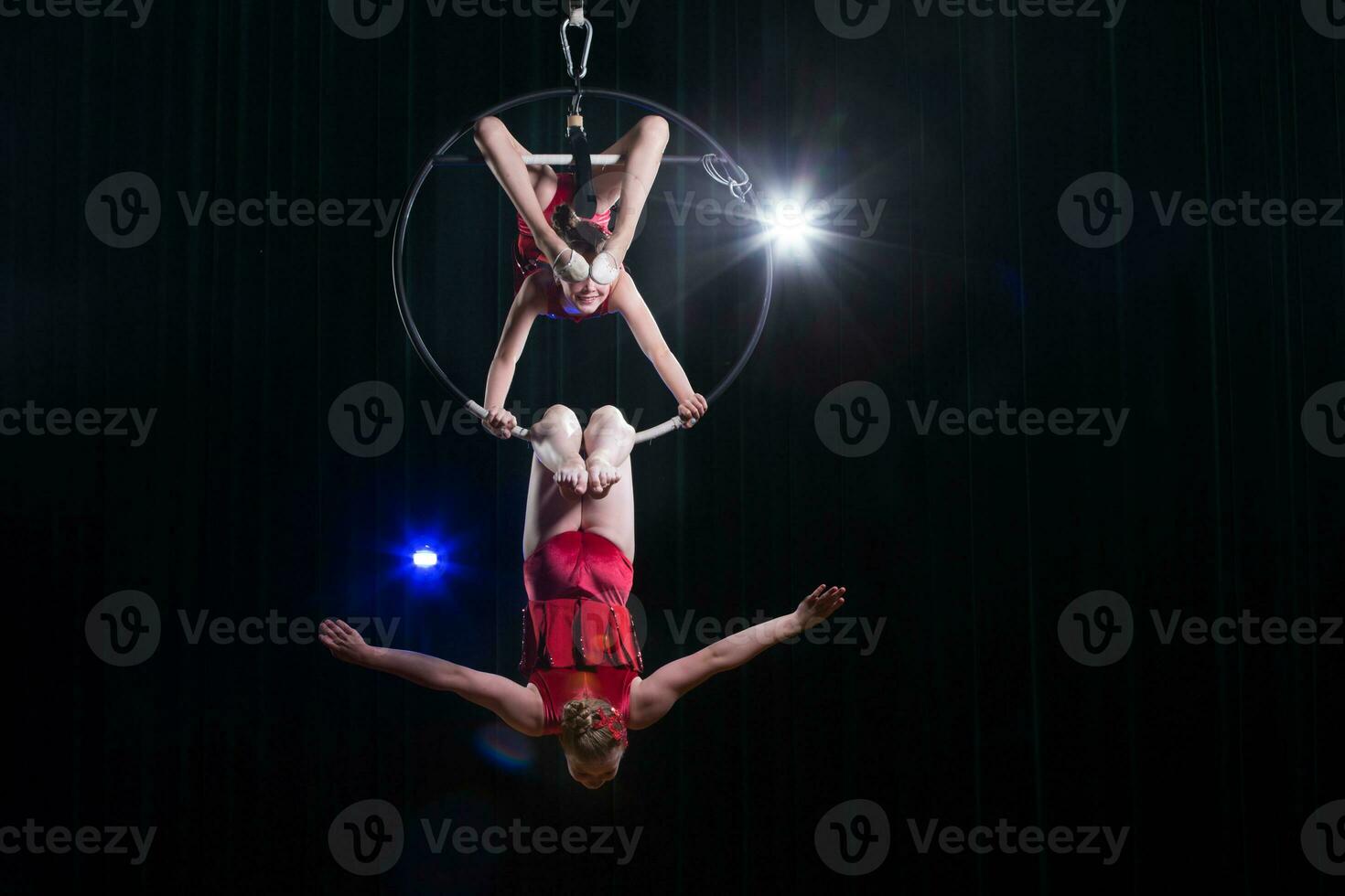 circo Actriz acróbata actuación. dos muchachas realizar acrobático elementos en el aire anillo. foto