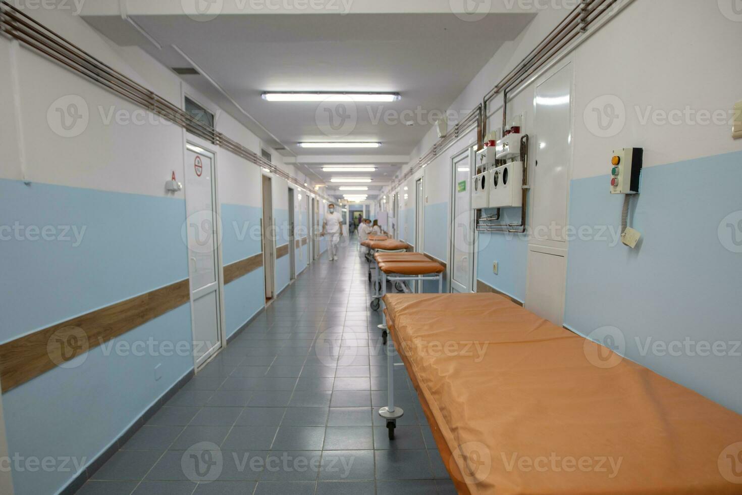 The long medical corridor of the hospital with doctors and medical gurneys. photo