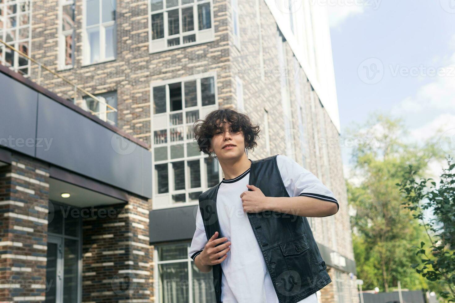 young man on the street against the backdrop of city buildings photo