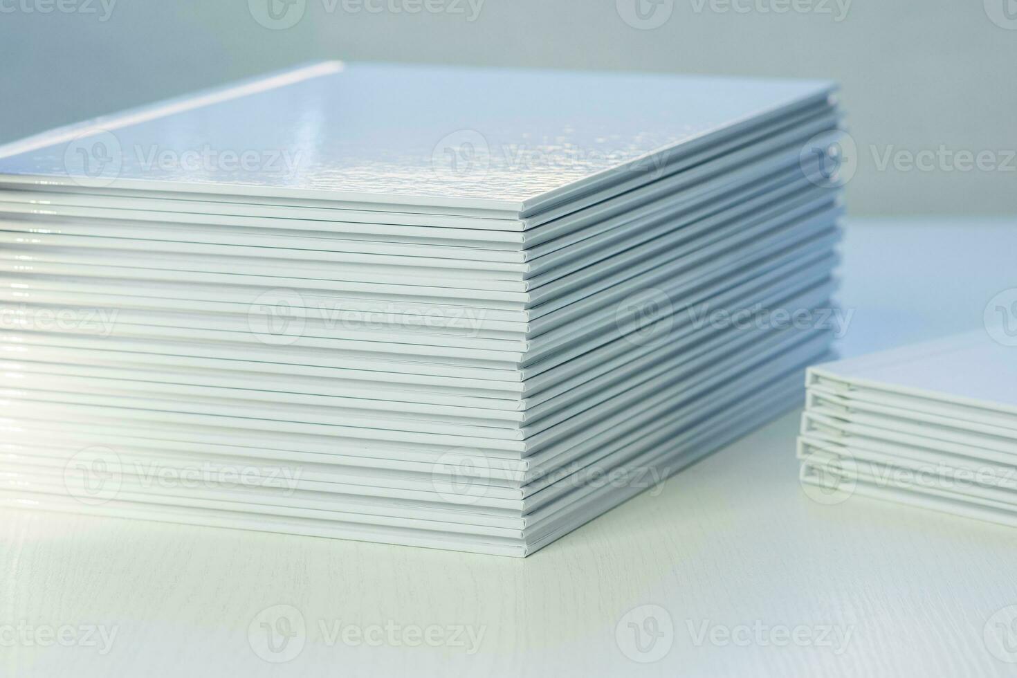 stacks of freshly printed photobooks with clean white covers on the table close-up photo
