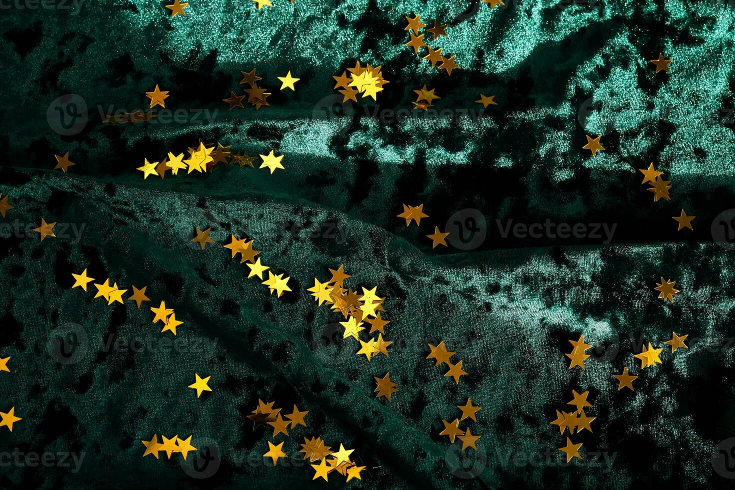 Abstract Christmas background with gold stars on a green velvet background. photo