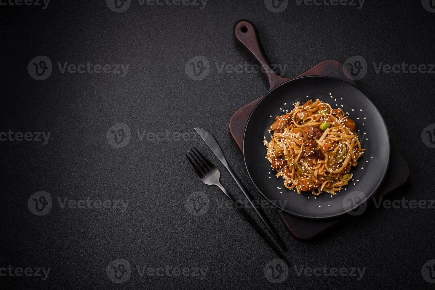 Delicious asian udon dish with vegetables, mushrooms, salt and spices photo