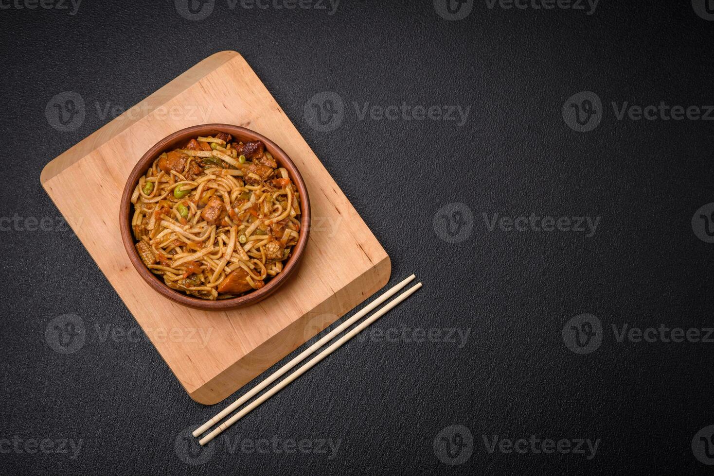 Delicious asian udon dish with vegetables, mushrooms, salt and spices photo