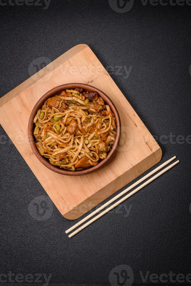 Delicious asian udon dish with vegetables, mushrooms, salt and spices photo