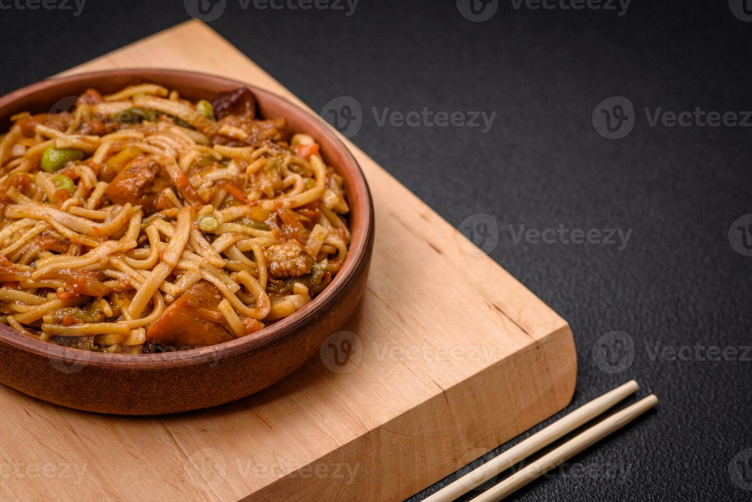 Delicious asian udon dish with vegetables, mushrooms, salt and spices photo