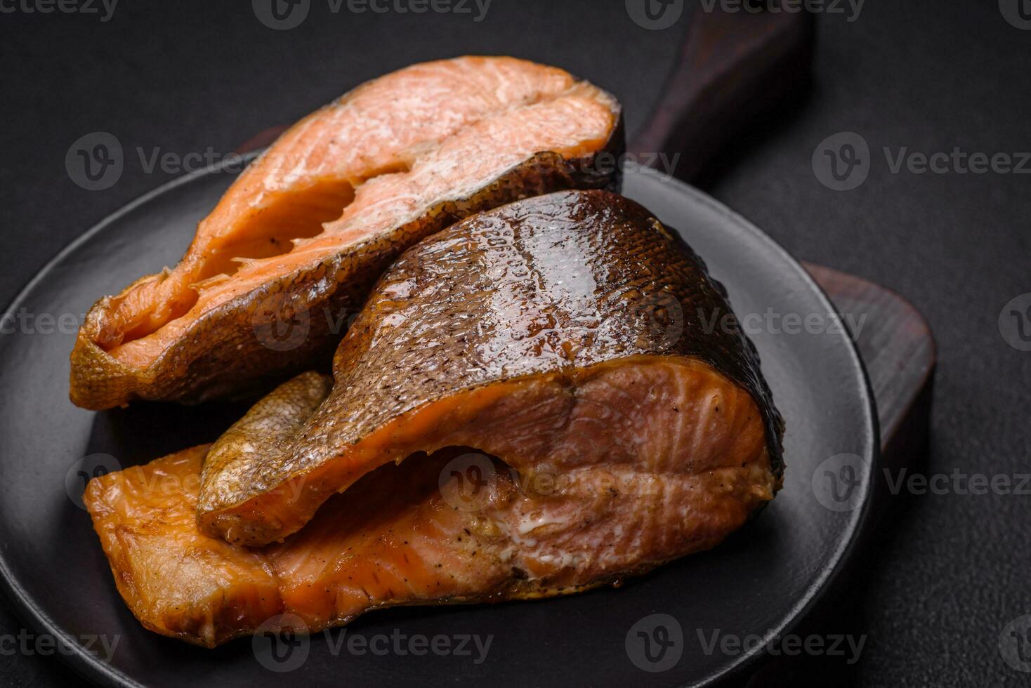 Fresh cooked delicious salmon steak with spices and herbs baked on a grill photo