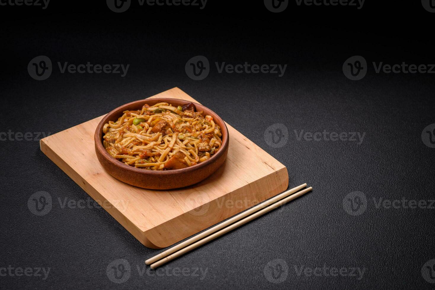 Delicious asian udon dish with vegetables, mushrooms, salt and spices photo