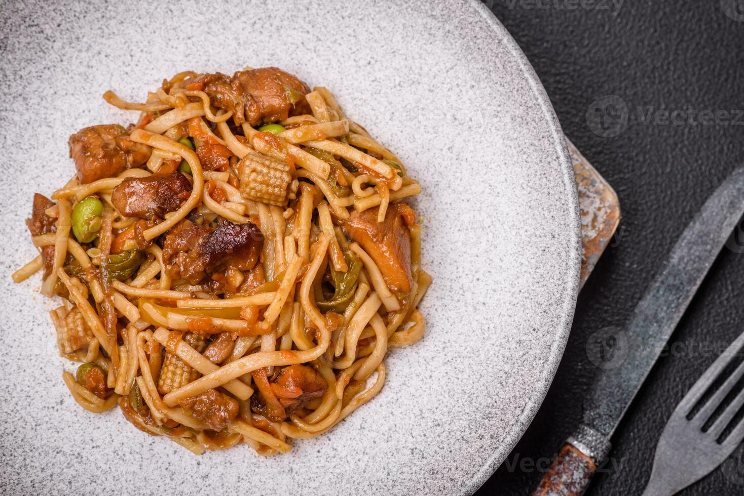 Delicious asian udon dish with vegetables, mushrooms, salt and spices photo