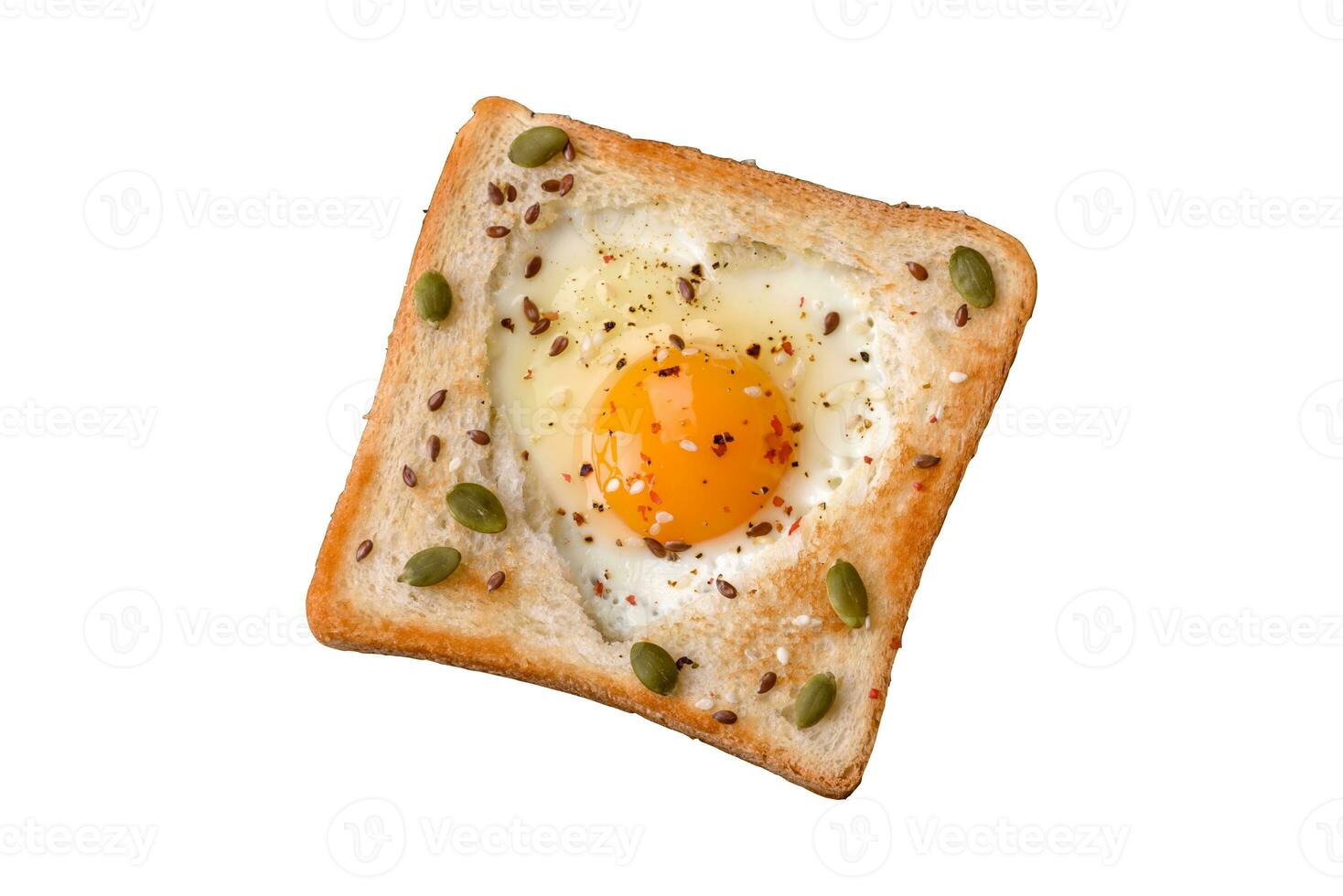 huevo frito en forma de corazón en pan tostado con semillas de sésamo, semillas de lino y semillas de calabaza en un plato negro foto