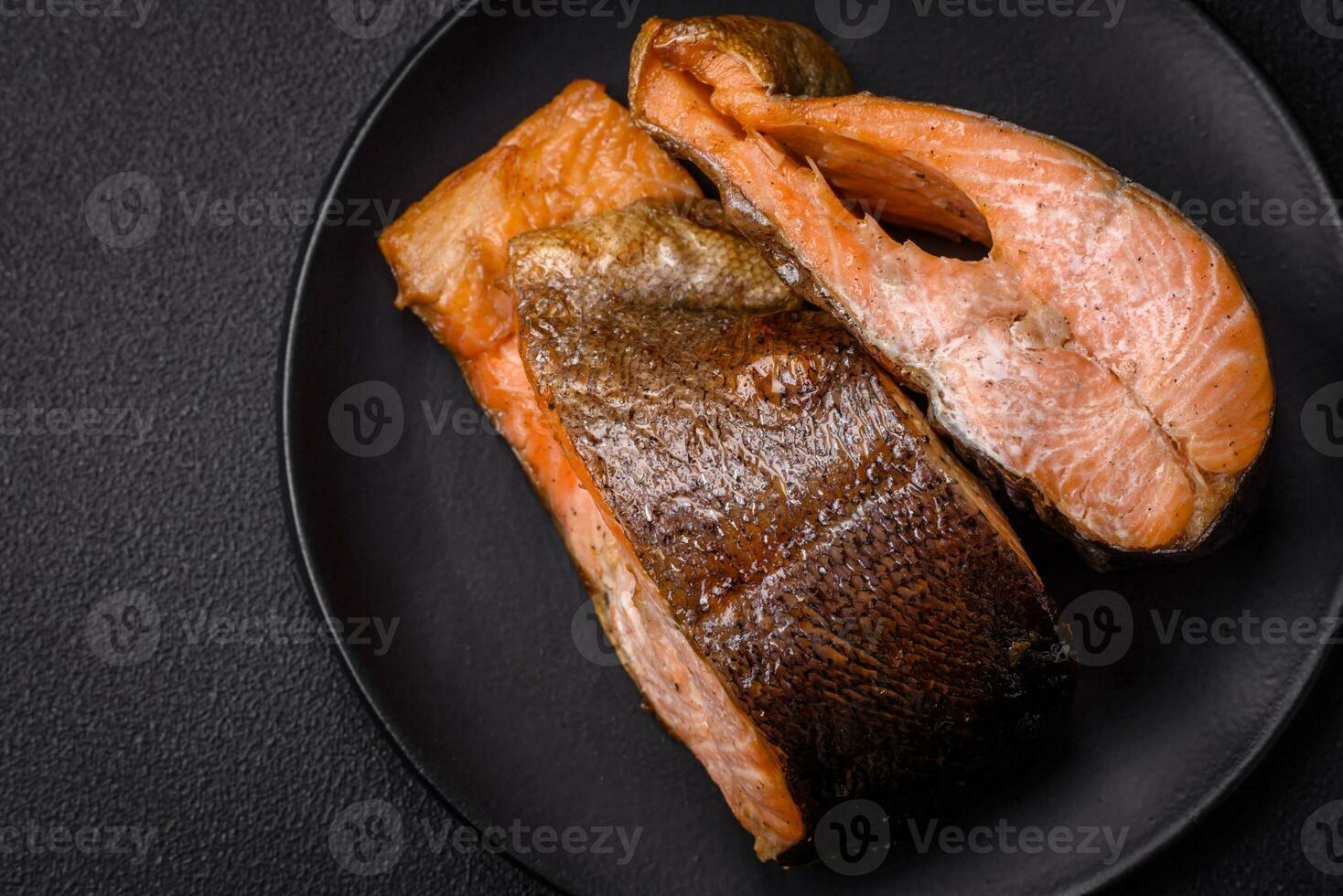 Fresh cooked delicious salmon steak with spices and herbs baked on a grill photo