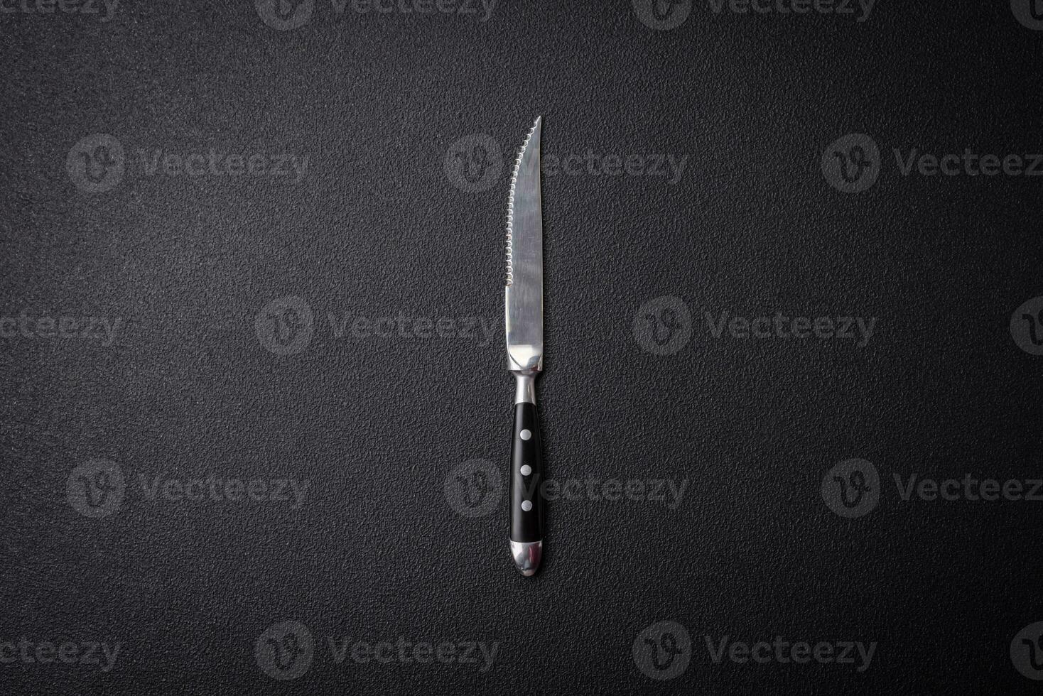 Kitchen knife made of steel on a dark textured background photo