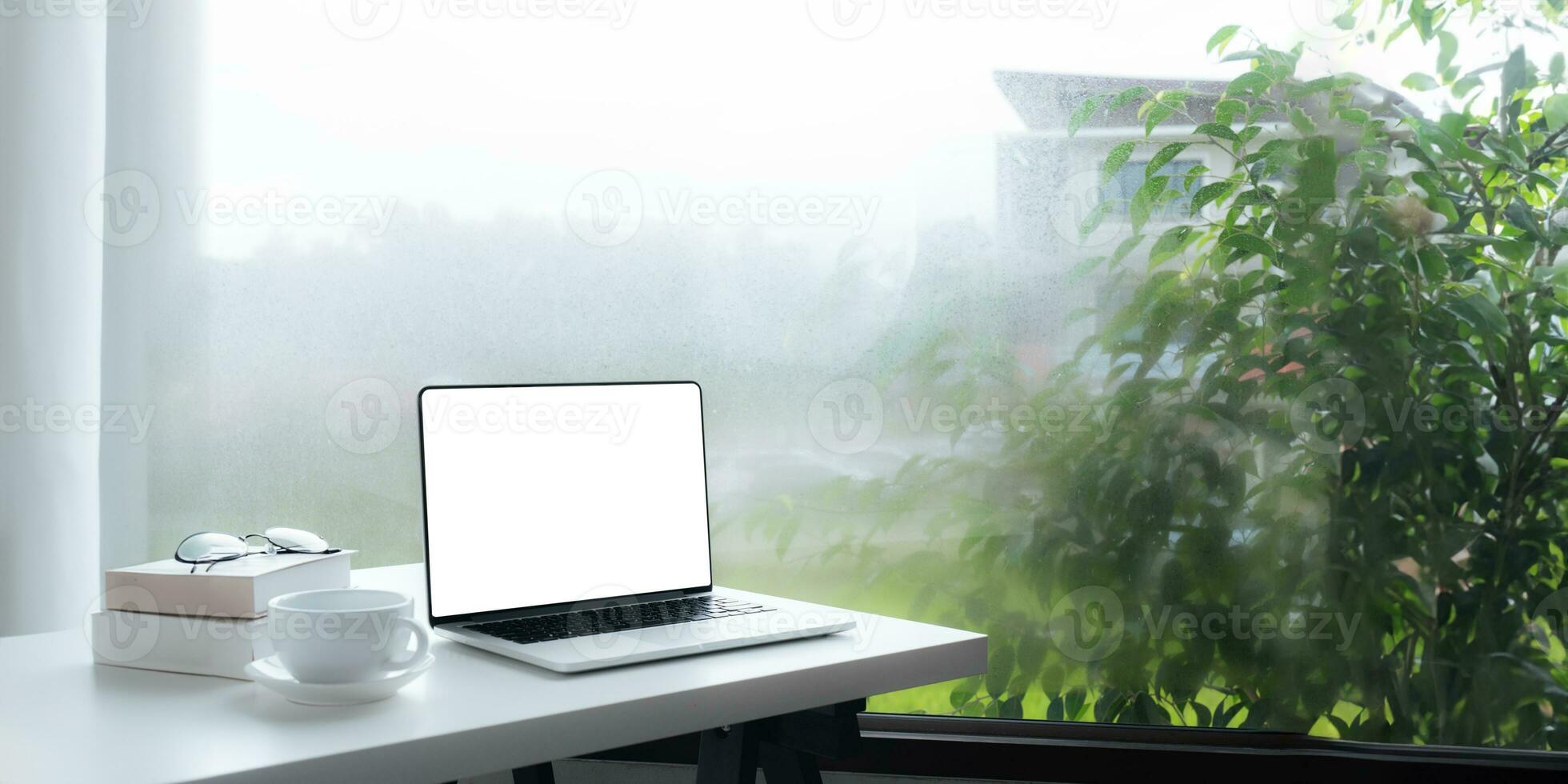 Image of working space by the window equipment in office interior, open laptop computer with mock up screen photo