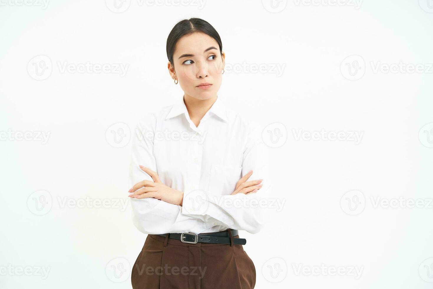 Image of office worker, female manager with crossed arms, looks thoughtufl aside, reads banner on white studio background photo