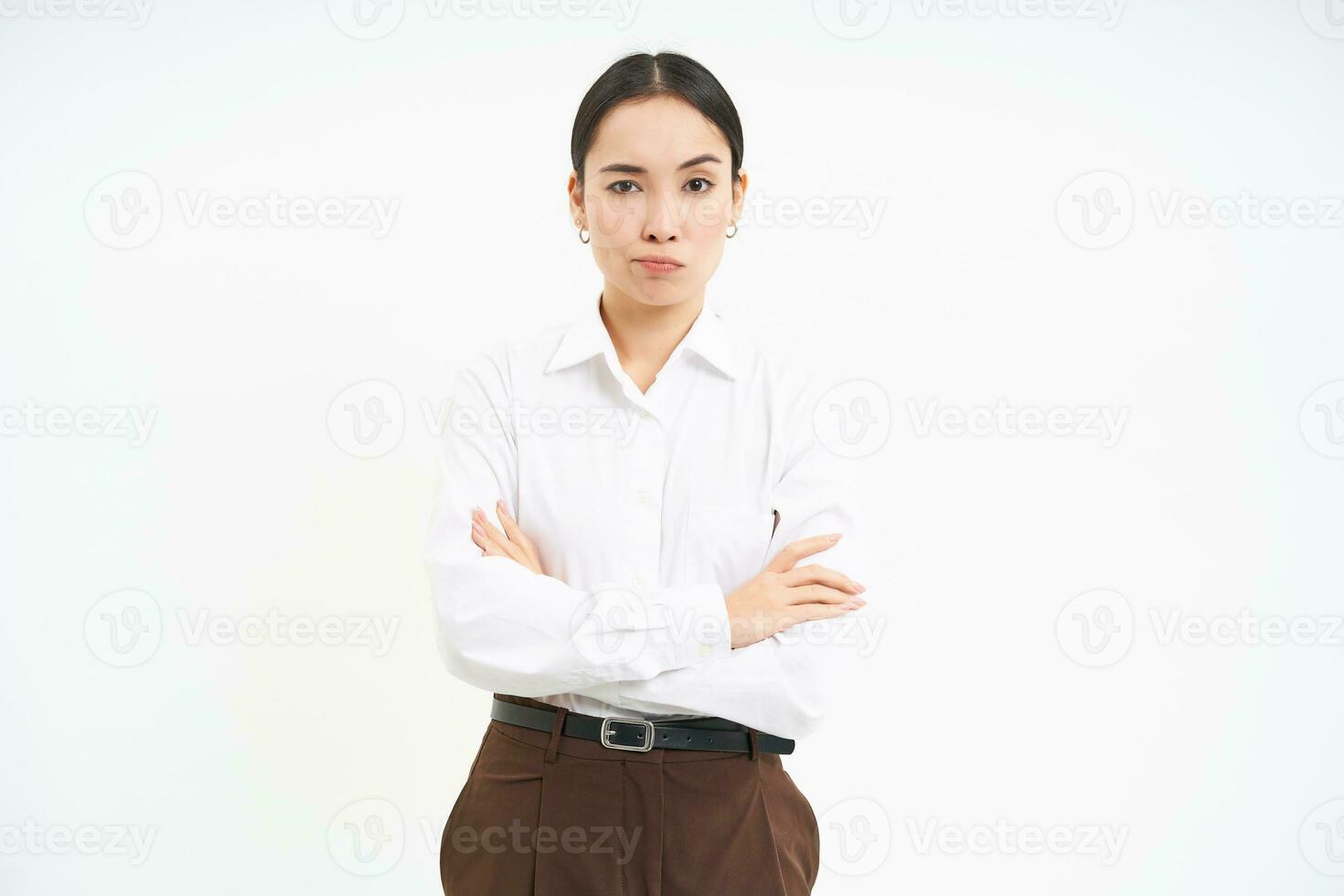 Portrait of upset, offended asian woman, cross arms on chest and looks away, frowning with disappointment, white background photo